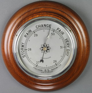 A 1930's aneroid barometer with silvered dial contained in a turned mahogany surround 7" 