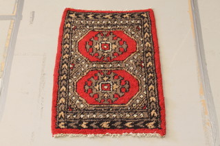 A red and white ground Uzbek "Bokhara" rug with 2 octagons to the centre 38" x 26" 