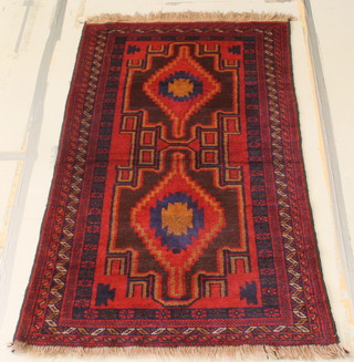 A red and blue ground Persian rug with 2 stylised diamonds to the centre within multi-row borders 52" x 39" 