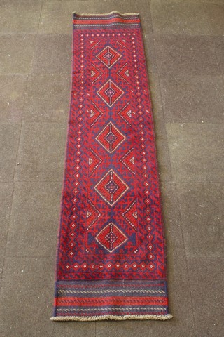 A red and blue ground Meshwani runner with 5 octagons to the centre within a multi-row border 104" x 24" 