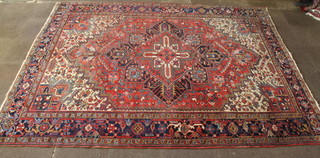 A Persian Heriz carpet with red white and blue ground and a stylised diamond medallion to the centre 136" x 102" 