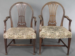 A pair of 19th Century Hepplewhite style bleached and carved mahogany carver chairs with over stuffed seats, raised on square tapering supports with H framed stretchers 