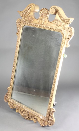A 19th Century oval bevelled plate wall mirror contained in a gilt painted frame with broken pediment surmounted by shells 38" x 24" 