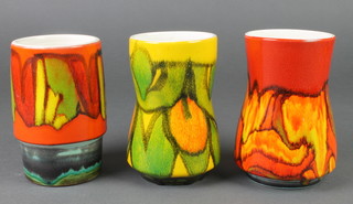 A Poole yellow ground waisted vase 83 6", a red ground ditto 83 6" and a cylindrical orange ground ditto 83 6" 