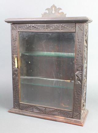 A Victorian deeply carved oak hanging cabinet, fitted shelves enclosed by a glazed panelled door 19"h x 13 1/2"w x 5 1/2"d  