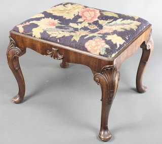 A Queen Anne style rectangular walnut stool with Berlin wool work seat, raised on carved cabriole supports, labelled Hamptons, 16"h x 21"w x 18"d 