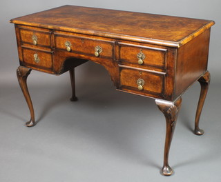 A Queen Anne style figured walnut writing table with quarter-veneered and crossbanded top, fitted 1 long and 4 short drawers, raised on cabriole supports, the knees carved shells, 30"h x 45"w x 22 1/2"d 