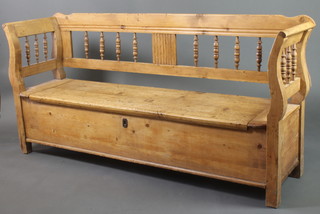 A 19th Century Continental stripped and polished pine settle, the raised back with spindle decoration 36"h x 75 1/2"w x 19"d 
