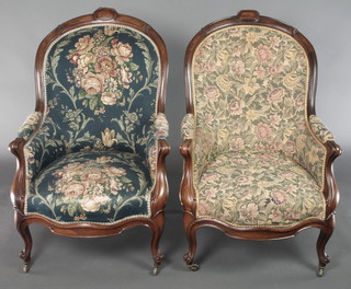 A pair of Victorian carved rosewood show frame tub back chairs upholstered in floral material and raised on cabriole supports 
