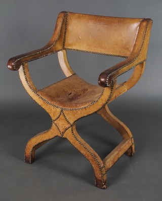An Italianate style open armchair upholstered in bleached brown leather 