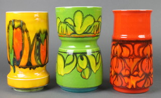 A Poole green ground waisted vase decorated with flowers 84 9 1/2", a red ground ditto 84 9" and an orange ground ditto 84 9" 