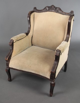 An Edwardian mahogany show frame armchair upholstered in mushroom coloured material, raised on cabriole supports  