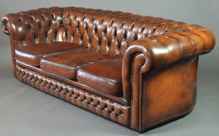 A Chesterfield 3 seat settee upholstered in brown buttoned leather 27"h x 81"w x 34"d 
