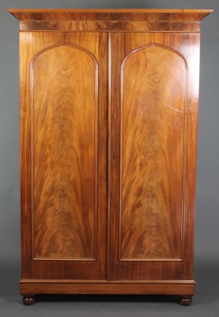 A Victorian mahogany Channel Islands knock down wardrobe with moulded cornice, fitted a shelf above a hanging cupboard and enclosed by a pair of arched panelled doors, raised on bun feet 85"h x 60 1/2"w x 25"d 
