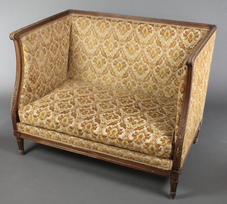 A French style carved walnut show frame settee upholstered in yellow sculptured floral material, raised on cabriole supports 