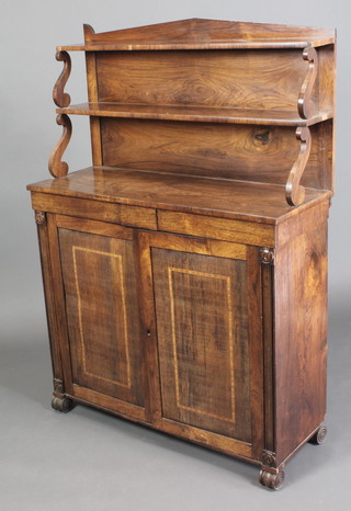 A Regency rosewood chiffonier, the raised back fitted shelves and scroll supports, the base fitted 2 short drawers above a cupboard enclosed by panelled doors, raised on scroll feet 55"h x 39"w x 14"d 
