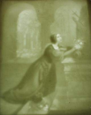 A 19th Century KPM lithophane depicting a lady in supplication  in a church holding a bouquet of flowers, stamped 334 9 1/2" x 7 1/2" 