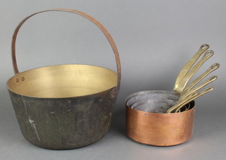 A circular brass preserving pan with iron handle 11" together with 6 graduated copper saucepans with brass handles 