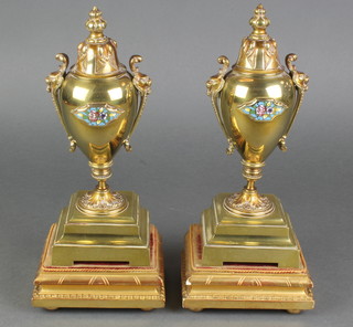 A pair of 19th Century gilt metal lidded urns with champleve enamelled panels, raised on bracket feet 9 1/2" 