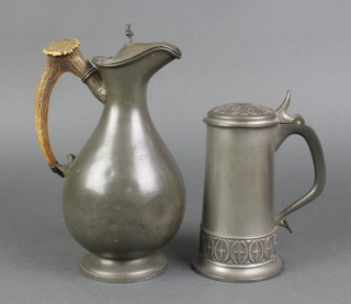 A Victorian pewter hot water ewer of baluster form with stag horn handle, raised on a circular spreading foot 9" (some dents) together with an Haugrud Norwegian pewter lidded tankard (dented) 