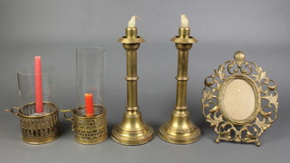 An oval pierced gilt metal easel photograph frame 11", a pair of 19th/20th Century brass storm lanterns with glass chimneys and a pair of brass sprung loaded candlesticks 12" 