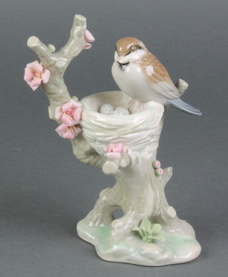 A Lladro figure of a bird sitting on its nest in a flowering tree 6" 