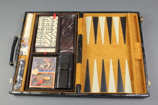 A cased games compendium with Backgammon, Dominoes, cards, dice etc 