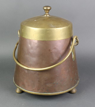 A copper and brass Dutch style peat bucket with swing handle, raised on 3 bun feet (slight dent to base) 16"