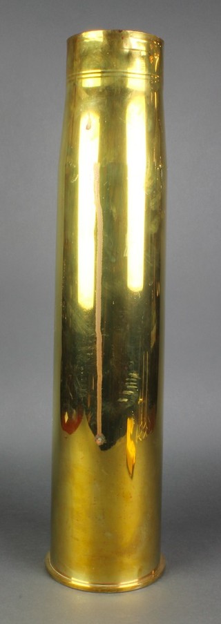 A large brass shell case, the base marked 105 x 617 DM5 24"h 