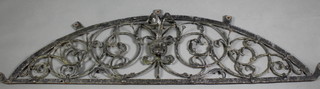 An antique wrought iron arched shaped panel decorated a mask 21"h x 24"w 