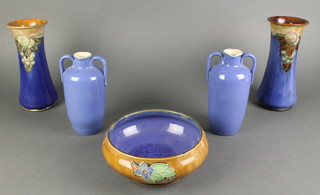 A Royal Doulton shallow bowl, the tan ground with stylised flowers and leaves 8", a pair of ditto blue glazed double spouted jugs 7" and a near pair of Royal Doulton vases, the blue ground with stylised fruits and leaves 10" 