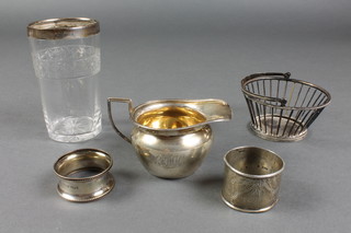 A Victorian silver cream jug, London 1889, 82 grams, 2 napkin rings, a Continental basket and a mounted beaker