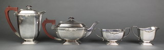 A silver 4 piece tea and coffee set with fruitwood handles and cast scroll decoration Birmingham 1958/9, 1830 grams gross.