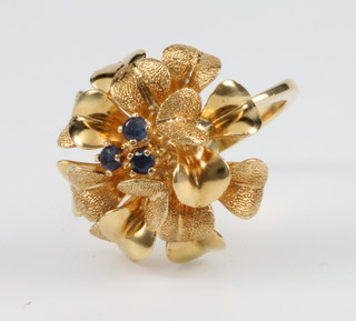 An 18ct yellow gold sapphire set floral ring, size K 1/2