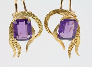 A pair of stylish 1970's 18ct yellow gold open scroll earclips set with an emerald cut amethyst approx. 3ct, gross 10 grams