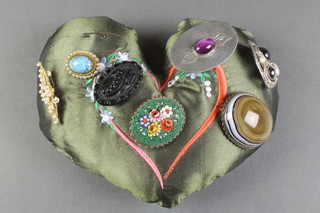 A banded agate brooch and 6 others on an embroidered silk heart shaped cushion 