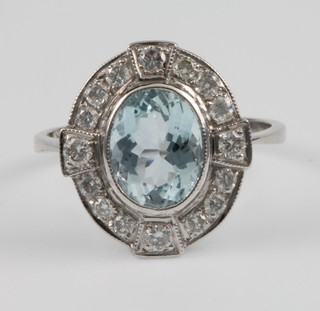 An 18ct white gold aquamarine and diamond opal dress ring, the centre stone approx. 1.5ct surrounded by 16 brilliant cut diamonds, size M 