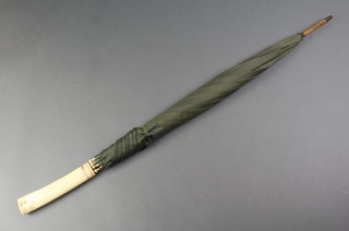 An Edwardian umbrella with a Japanese carved ivory handle decorated with peony 