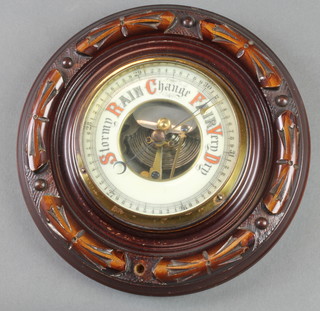 An Edwardian aneroid barometer with enamelled dial contained in a carved mahogany roundell case 8" diam. 