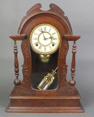 An American striking shelf clock with paper dial and Roman numerals contained in an arched carved walnut case and with twin pillar pendulum 