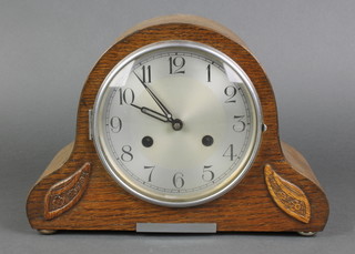 A 1930's striking mantel clock with silvered dial and Arabic numerals contained in an oak arch shaped case 