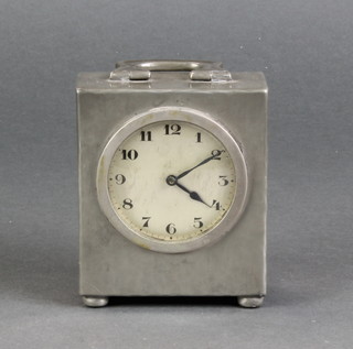 Liberty's, an Art Nouveau bedroom timepiece with silvered dial and Arabic numerals, contained in a rectangular planished pewter case, raised on bun feet, the base marked 0581 English Pewter, Made by Liberty's 