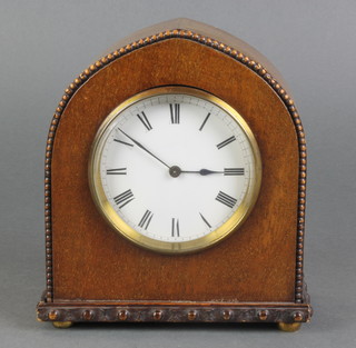 An Edwardian bedroom timepiece with enamelled dial and Roman numerals contained in an arched mahogany case