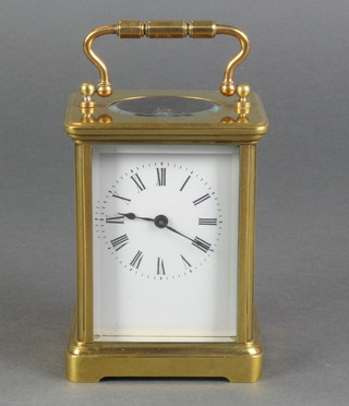A French 8 day carriage timepiece with enamelled dial and Roman numerals contained in a gilt metal case 