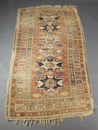 A Caucasian rug with 6 stylised octagons to the centre within a multi row border, some wear and a tear to the centre 91" x 49" 