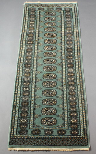 A green ground Bokhara runner with 16 octagons to the centre 71" x 25" 