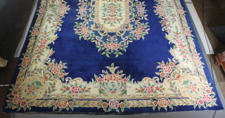 A blue and floral ground Chinese carpet with central medallion, the fringe has been removed and there is a slight tear 145 1/2" x 109 1/2" 