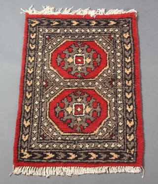 A Uzbek "Bokhara" red ground rug with 2 octagons to the centre 37" x 25" 