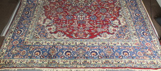 A fine Persian Isfahan blue and red ground carpet, signed, some wear, 166" x 114" 