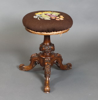 A Victorian carved walnut adjustable piano stool raised on a tripod base 19"h x 15" diam. 